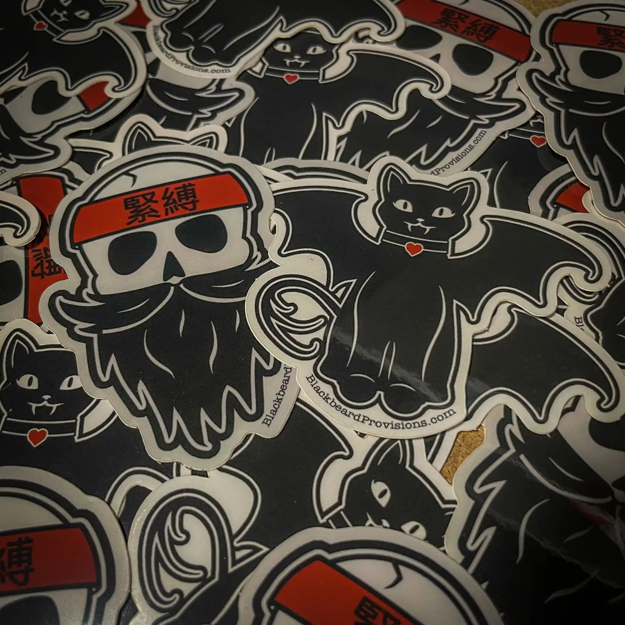 Collection of black and red stickers featuring cats and bearded skull designs.